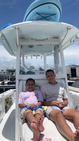 Two children relax on the deck of a boat, showcasing a fun day on the water with snorkeling gear at hand — perfect for family adventures.