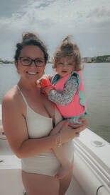 A joyful moment captured of a mother holding her child on a boat, showcasing a perfect family outing on the water.