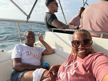 Two friends enjoy a sunny day on a boat, capturing a joyful moment together — perfect for celebrating special occasions on the water.