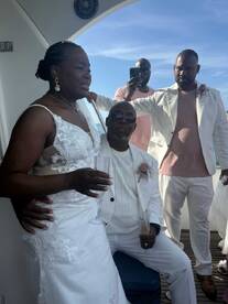 A heartfelt moment during a wedding celebration aboard a boat, capturing the couple and their guests in a beautiful setting.