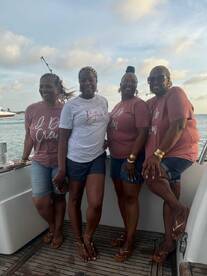 A joyful group of friends poses together on a boat, showcasing their matching shirts and celebrating their time on the water — perfect for memorable outings and gatherings.
