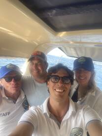 A cheerful group of boat staff poses for a selfie aboard a vessel, showcasing the friendly atmosphere of a boating experience.
