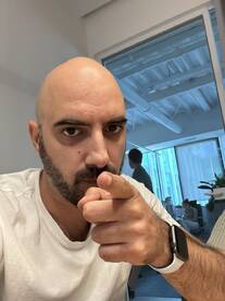 A man points directly at the camera in an office setting, creating an engaging and direct connection with the viewer.