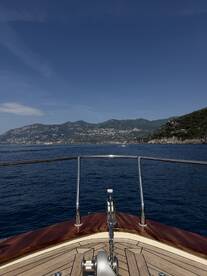 A stunning view from the front of a yacht, showcasing the serene blue waters and picturesque coastline, perfect for luxury boating experiences.
