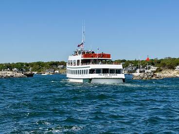 The Island Queen ferry navigates through the waters, showcasing its vibrant design against a picturesque coastal backdrop — perfect for scenic tours in Falmouth.