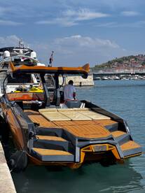 A sleek speedboat docked at the marina, showcasing its modern design and spacious seating area — perfect for thrilling water adventures.