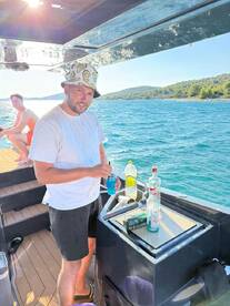 A man prepares colorful cocktails on a boat, showcasing the perfect setup for a fun day on the water. Enjoying drinks while cruising is an essential part of any boating adventure.