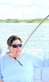 A woman enjoys a scenic boat ride, taking in the views of the water and surrounding greenery — a perfect moment for relaxation on the water.