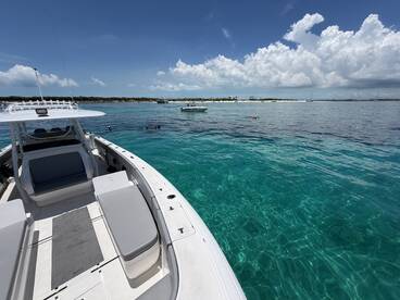 A vibrant scene showcasing a boat anchored in crystal-clear waters, with snorkelers enjoying the underwater beauty — perfect for summer adventures and island explorations.