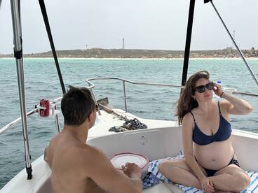 A couple enjoys a relaxing moment on a boat, surrounded by beautiful ocean views — perfect for a romantic getaway or vacation.