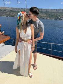 A couple shares a romantic kiss aboard a yacht, surrounded by stunning coastal scenery — perfect for memorable moments on the water.