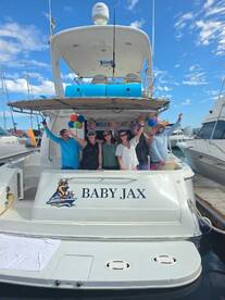 A lively group celebrates aboard the 'Baby Jax' yacht, showcasing a festive atmosphere with balloons and smiles — perfect for memorable gatherings on the water.