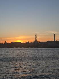 A stunning sunset over the harbor, featuring silhouetted masts and a peaceful water view — perfect for capturing the beauty of evening boat trips.