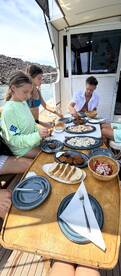 Guests enjoy a delicious onboard meal featuring a variety of dishes, perfect for enhancing the boating experience.