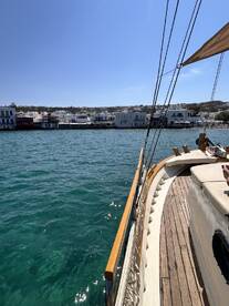 A scenic view of a yacht's side as it sails past charming waterfront buildings, showcasing the beauty of coastal life.