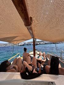A group of friends relaxes on the deck of a boat, enjoying the sun and beautiful views — perfect for a day of leisure on the water.