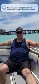 A man enjoys a relaxing moment on a boat, surrounded by beautiful turquoise waters — a perfect snapshot of a memorable boating trip.