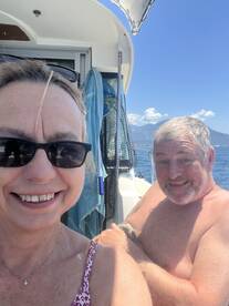A cheerful couple enjoys a sunny day on the boat, capturing a joyful moment together — perfect for memorable outings on the water.