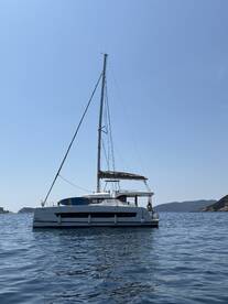 A stunning side view of a Bali catamaran sailing in calm waters, showcasing its sleek design against a clear blue sky.