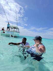 Guests enjoy a refreshing swim in crystal-clear waters while fishing from the boat 'Trinity' — a perfect day for aquatic adventures.