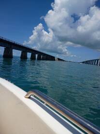 A scenic view of bridges spanning over turquoise waters, showcasing the beauty of the coastline and the vibrant sky — perfect for capturing the essence of a boating adventure.