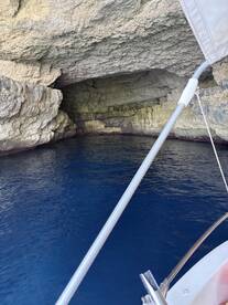 A stunning view of a cave entrance from a boat, showcasing the vibrant blue water and textured rock formations — perfect for exploring hidden gems on your boating adventure.