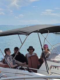 A cheerful group of friends enjoys a sunny day on a boat, perfect for creating unforgettable memories on the water.