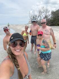 A fun group of friends enjoys a beach day, capturing memories with smiles and drinks in hand — perfect for summer outings and celebrations.