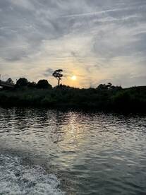 A serene sunset over calm waters, reflecting the vibrant colors of the sky — a perfect moment for relaxation and enjoying nature's beauty.