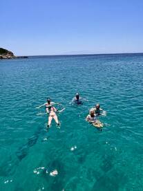 A group of friends enjoys a refreshing swim in crystal-clear waters, perfect for a fun day out on the boat.
