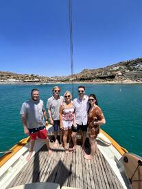 A cheerful group of friends poses together on the deck of a boat, enjoying a sunny day on the water — perfect for memorable outings and celebrations.