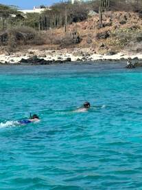 Two snorkelers explore the vibrant underwater world in crystal-clear turquoise waters, showcasing the beauty of beach adventures.