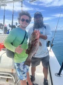 Two anglers proudly display their catch aboard a fishing boat, celebrating a successful day on the water. Perfect for fishing enthusiasts and adventure seekers.