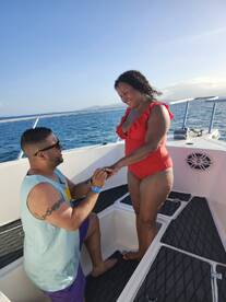 A romantic moment captured on a boat as a couple celebrates a proposal, surrounded by stunning ocean views — perfect for unforgettable love stories.