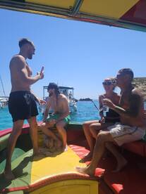 A lively group enjoys a fun boat party, sharing drinks and laughter under the sun — perfect for memorable outings on the water.