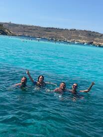 A joyful group of friends enjoys a refreshing swim in the stunning turquoise waters, capturing the essence of a perfect day on the water.