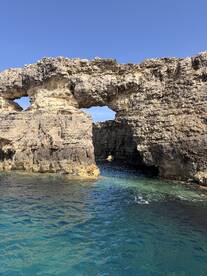 A stunning view of natural rock formations rising from crystal-clear waters, perfect for exploring coastal landmarks and enjoying scenic boat trips.