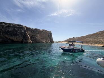 A scenic view of a boat navigating through the stunning coastline of Malta, showcasing the beautiful turquoise waters and rocky cliffs — perfect for exploring the island's natural beauty.