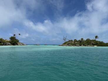 A stunning view of a tropical island surrounded by crystal-clear turquoise waters, perfect for island hopping adventures and scenic boat trips.