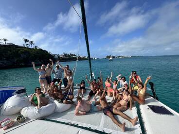 A lively group of friends celebrates on the deck of a yacht, enjoying the sun and water in a vibrant atmosphere — perfect for unforgettable summer outings.