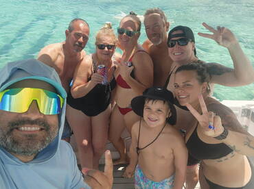 A joyful group of friends and family enjoys a fun day in the water, capturing memories with smiles and drinks in hand — perfect for summer celebrations.