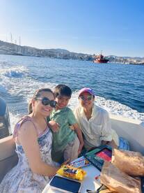 A joyful family enjoys a boat ride, sharing snacks and smiles against a scenic waterfront backdrop — perfect for family outings and adventures on the water.