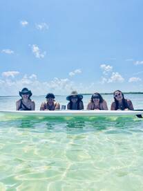 A cheerful group of friends enjoys a sunny day in the water, showcasing the perfect beach vibe and fun in the sun.