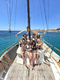 A lively group of friends enjoys a sunny day on a boat, celebrating together with smiles and peace signs — perfect for memorable outings and adventures on the water.