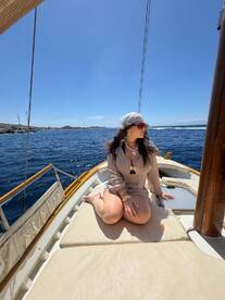 A woman enjoys a sunny day on the deck of a boat, capturing the essence of relaxation and adventure on the water.