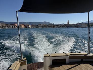 A scenic view from a boat cruising along the coastline, showcasing the beautiful waterfront architecture and clear blue waters.