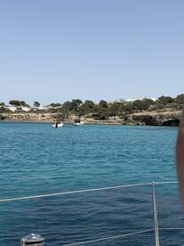 A picturesque view of boats navigating through turquoise waters, with a beautiful coastline in the background — perfect for showcasing scenic boat trips.