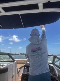 A captain gestures while navigating a boat in Key West, showcasing the vibrant boating experience in sunny waters.