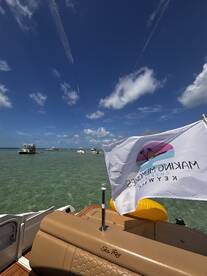 A scenic view from the deck of a Sea Ray boat, showcasing clear waters and a vibrant sky, perfect for enjoying a day on the water in the Florida Keys.