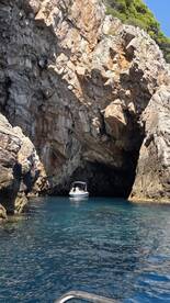 A boat navigates through a stunning cave, showcasing the natural beauty of the coastline — perfect for adventure seekers exploring hidden gems on the water.